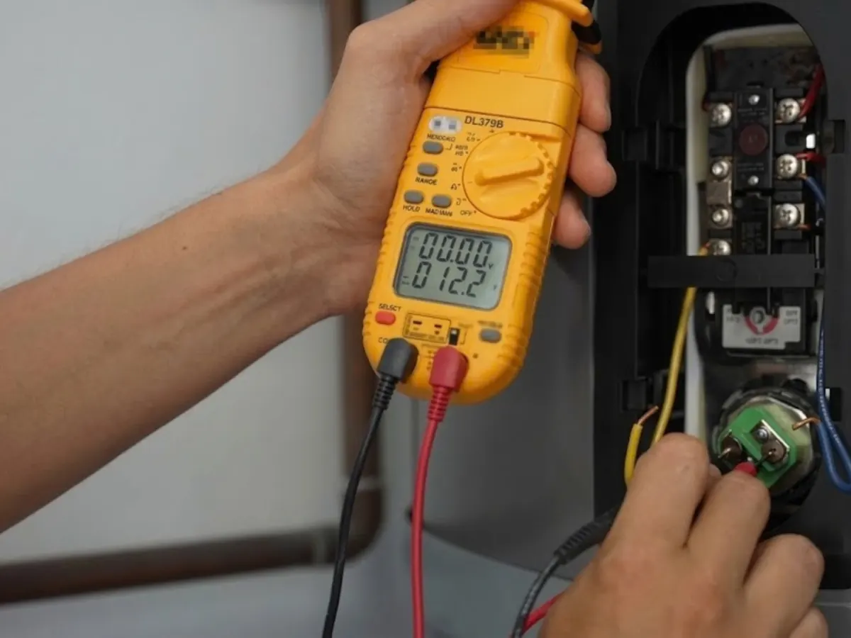 Technician testing a water heater thermostat with a multimeter